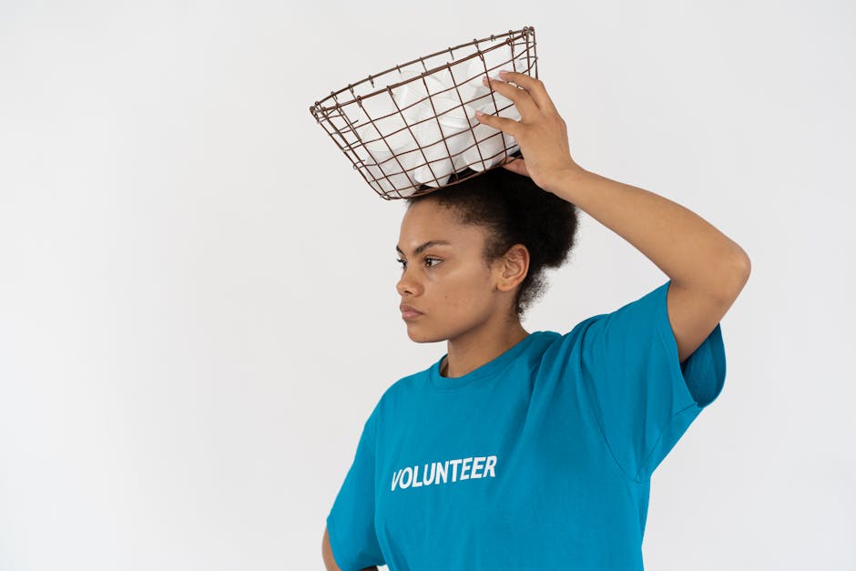 Le bénévolat répond-il réellement à notre besoin de sens ? African American environmentalist in blue volunteer shirt carrying recyclables in a metal basket.