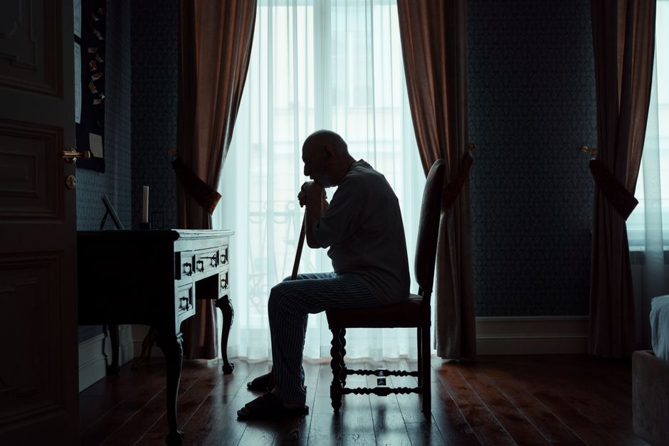 Lonely person sitting by a window in soft light