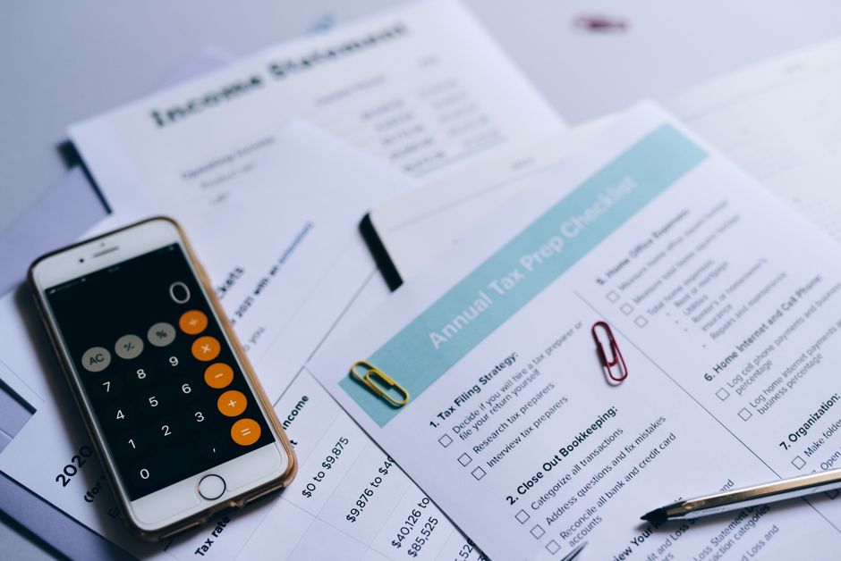 Person reviewing documents and paying taxes with a calculator