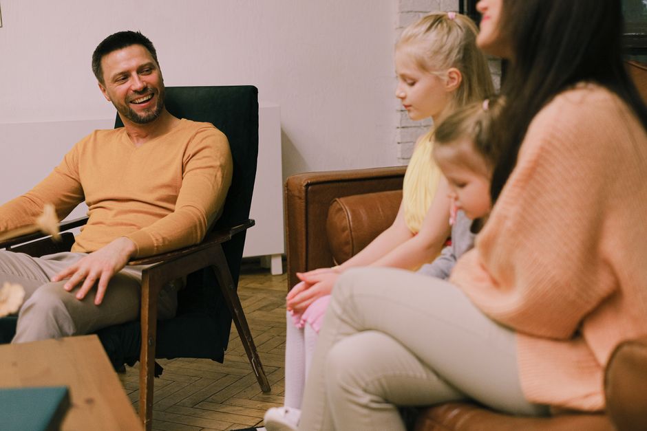 A cheerful family sitting together in the living room, sharing smiles and conversations.