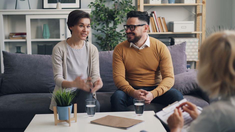 Thérapie familiale structurale : lire les liens, changer les interactions A couple discussing with a therapist during a counseling session indoors.