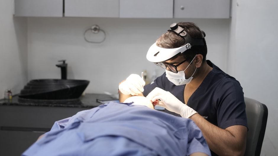 A dermatologist conducts a skin treatment on a patient in a modern clinic setting.