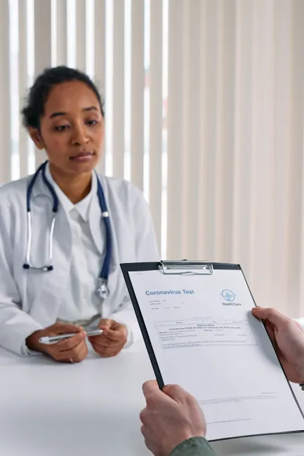 A doctor discusses coronavirus test results with a patient in a medical office.