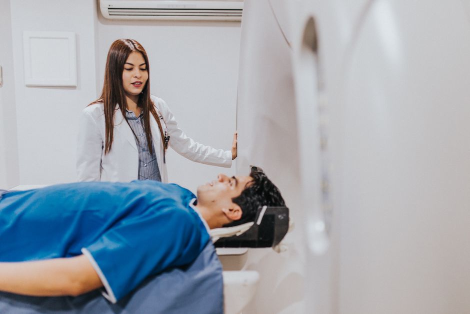 Trouble bipolaire résistant aux traitements : ce que ce terme signifie A doctor stands beside a patient in an MRI room, ensuring a smooth examination process.
