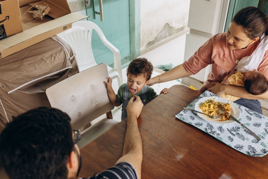 A family enjoys a meal together at a dining table, depicting a warm and intimate family moment.