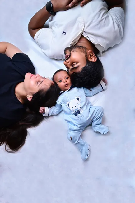 A joyful family portrait with parents and their adorable newborn, full of warmth and love.