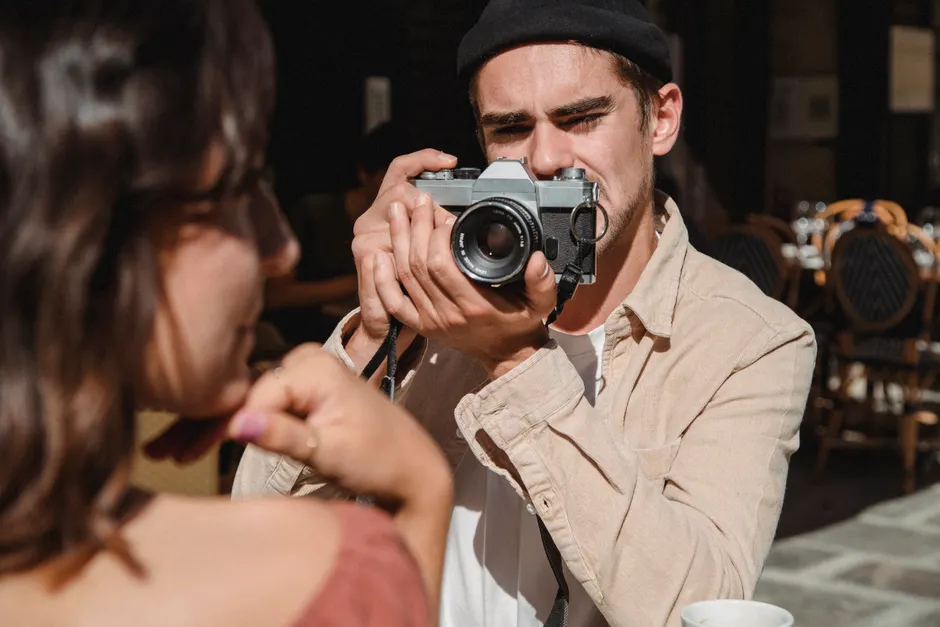 Exercice et trouble bipolaire : ce que la recherche permet d’espérer, sans fausse promesse A man taking a photo of a woman with a vintage camera in an outdoor cafe setting.