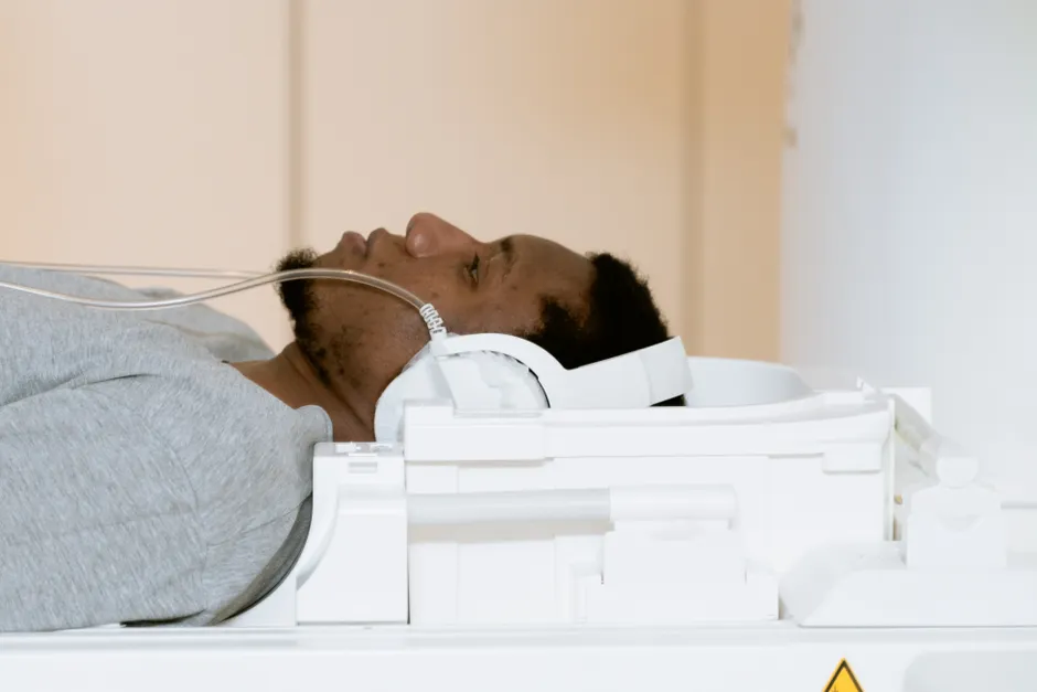 A patient is lying inside an MRI scanner for a medical examination indoors.