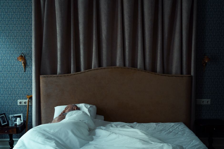 A serene bedroom with a man sleeping, evoking a sense of tranquility and comfort.