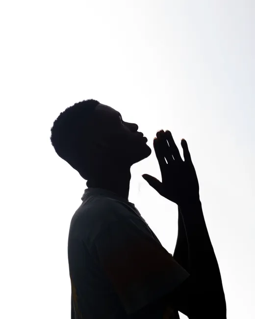 A silhouette of a person praying, showcasing devotion and peace.