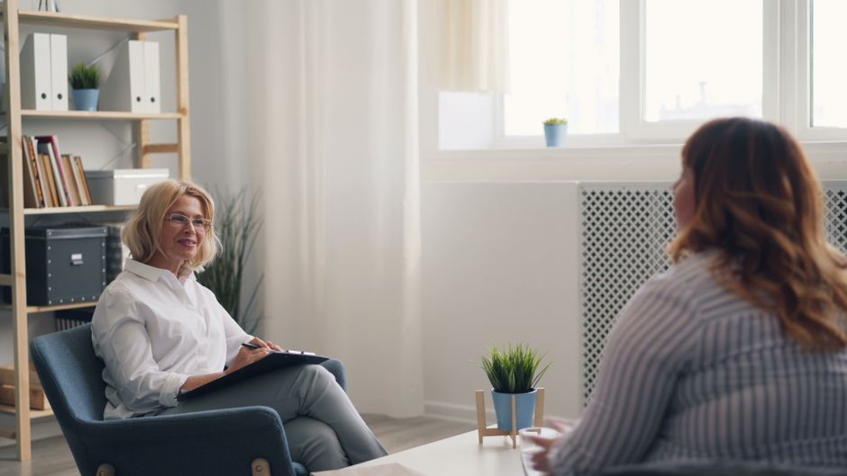 Psychothérapie : ses bénéfices varient selon le problème traité A therapist and a client engaging in a counseling session in a bright, modern office.