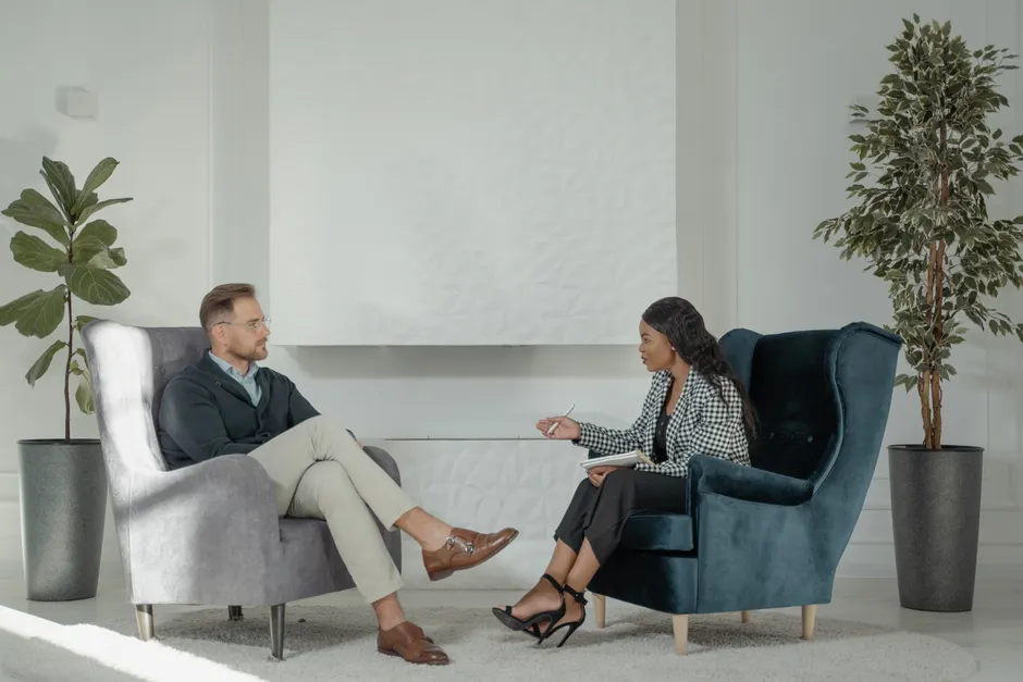 TOC et trouble bipolaire : quand les symptômes se brouillent A therapist and patient engaged in conversation in a modern, stylish therapy office.