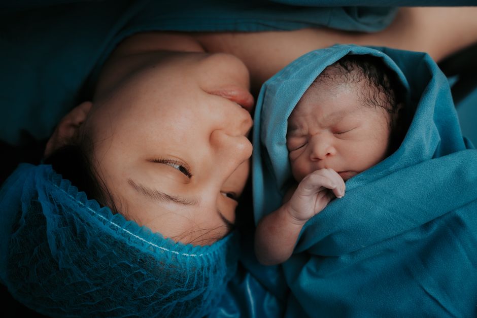 PTSD post-partum : quand l’accouchement reste une alerte A touching image of a mother and her newborn baby wrapped in blue medical blankets.