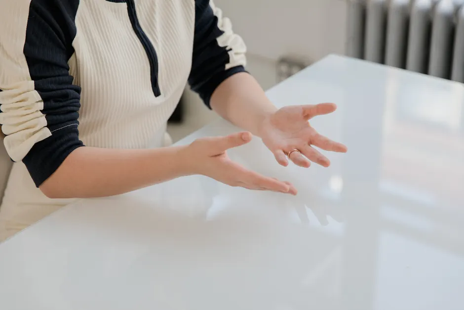 Close-up of a person's hands gesturing expressively indoors.