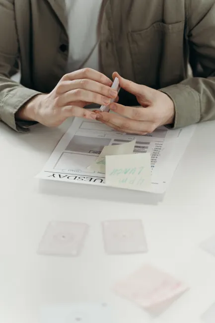 Close-up of hands planning and organizing business strategy with documents and notes.
