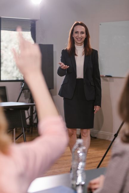 Confident businesswoman speaking to a team during a meeting indoors.
