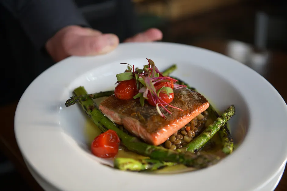 Delicious gourmet salmon served with lentils, asparagus, and cherry tomatoes.