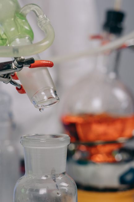 Detailed view of lab glassware with tubes and clamps in a laboratory setting.