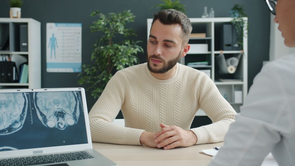 TDAH et trouble bipolaire : pourquoi les symptômes se ressemblent et comment les différencier Doctor reviews brain scan results with patient during consultation.