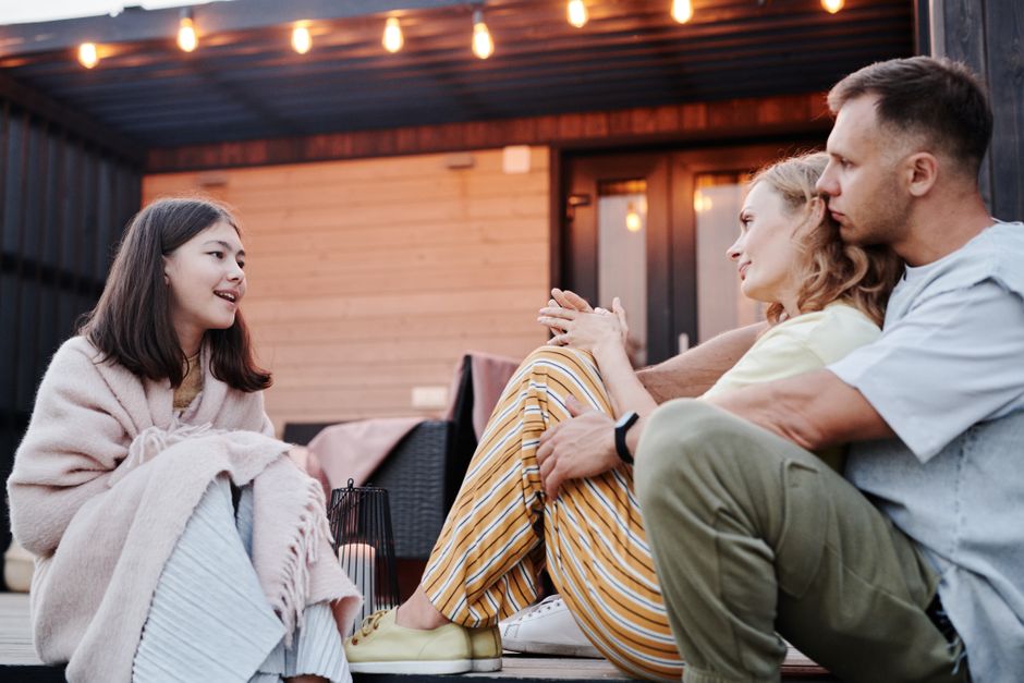 Family enjoying a warm conversation on a cozy patio in the evening.