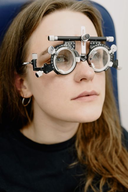 Female patient in glasses for checking vision during appointment in modern ophthalmology clinic