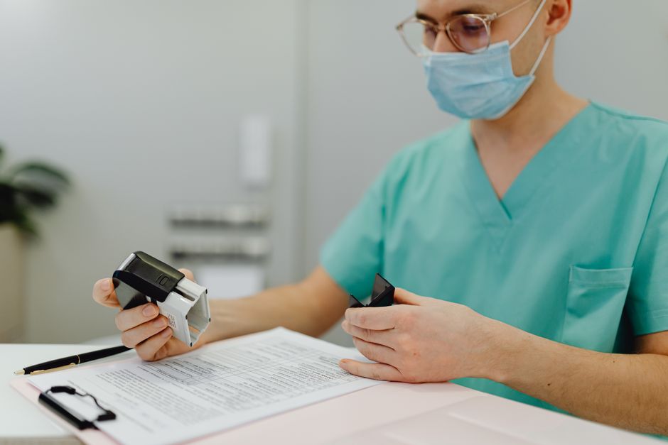 Trouble schizoaffectif ou trouble bipolaire : le diagnostic se joue dans le temps Healthcare worker in scrubs reviewing patient files with a stamp and clipboard.