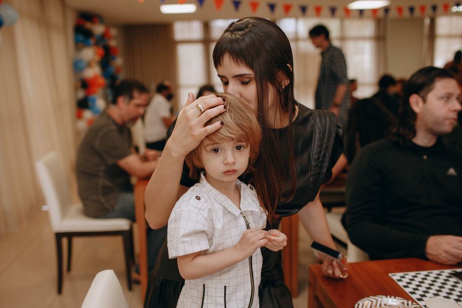 Mother comforting her child during an indoor family gathering. Warm and candid moment captured.