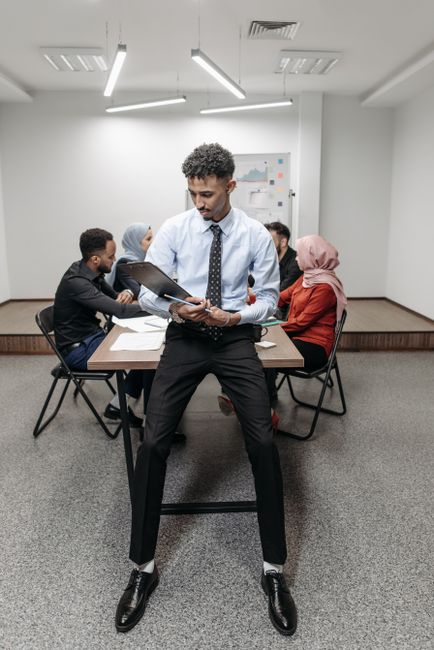 Office worker holding a clipboard during a meeting, capturing a diverse team collaborating.