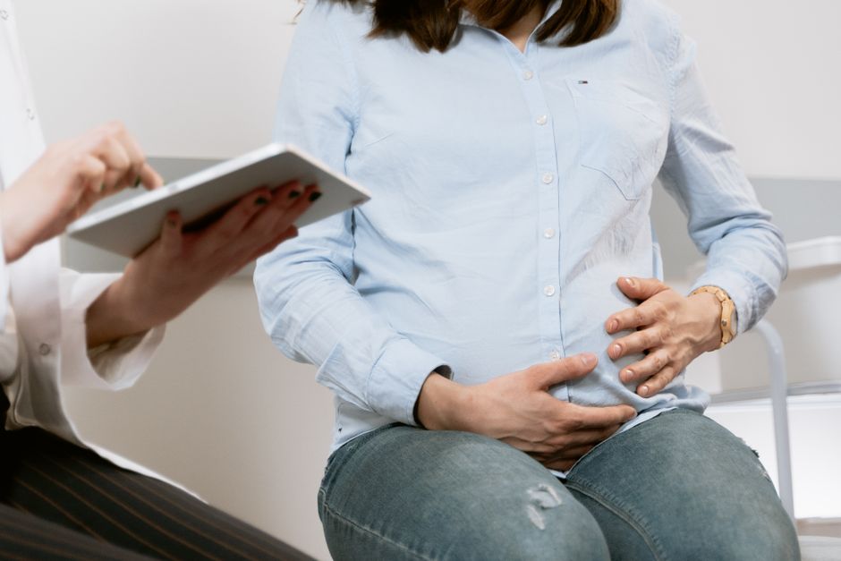 Trouble bipolaire en 2025-2026 : grossesse, manie et proches aidants Pregnant woman attending a healthcare consultation, showcasing doctor-patient interaction.