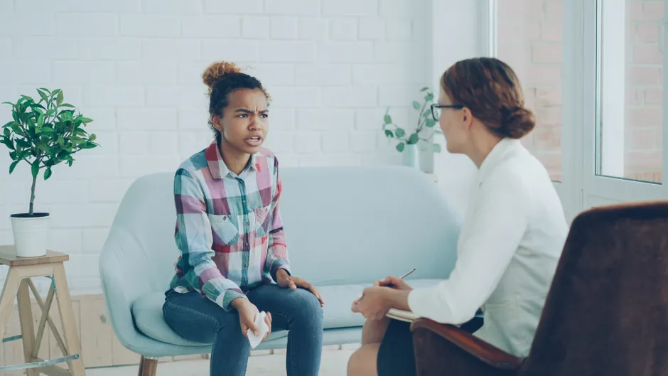 Therapist and patient in conversation during a counseling session indoors.