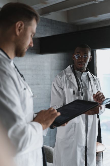 Two doctors reviewing patient information on a tablet in a modern office setting.
