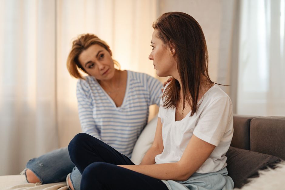 Trouble bipolaire et entourage : aider sans s’épuiser Two women having a heartfelt conversation on a couch, showing empathy and support.