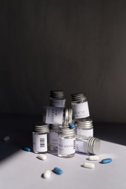 Various medicine bottles and pills arranged artfully on a white background.