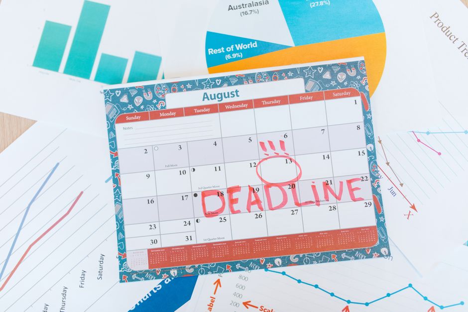Penser à la mort et compter ses lundis : clarifier ses priorités sans compte à rebours Vibrant August calendar on a desk with deadline marked in red, surrounded by graphs and charts.