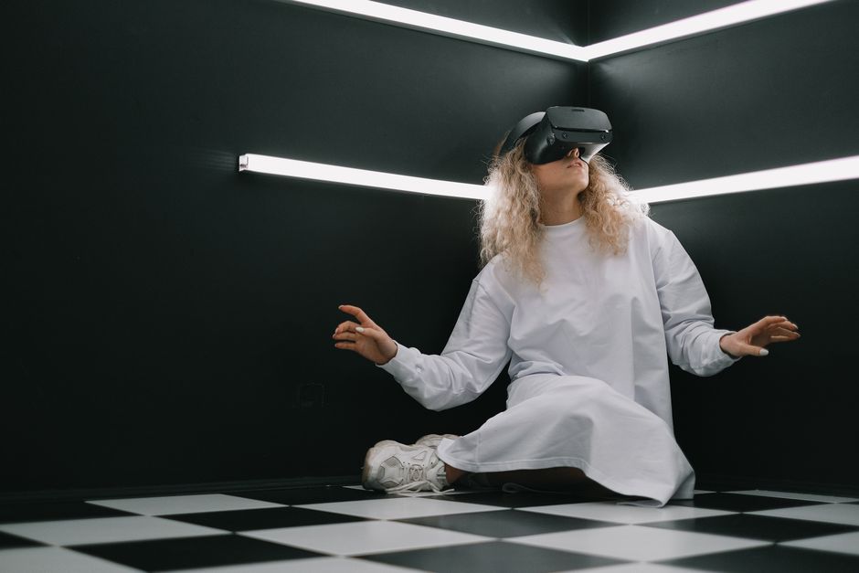 Woman wearing a VR headset in a stylish room, exploring virtual reality.