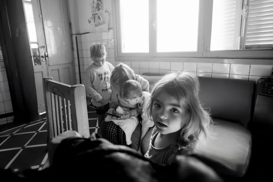 A candid black and white photo of children interacting indoors, creates a classic moment.