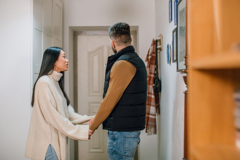 Attachement désorganisé : quand l’intimité attire et fait fuir A couple engages in a serious conversation, holding hands inside a cozy home.