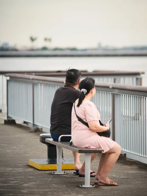 A couple sitting on a bench, enjoying a peaceful waterfront view.