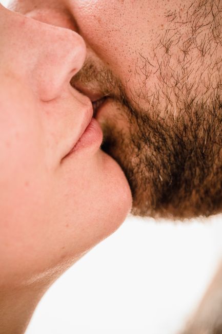 A detailed and intimate close-up of a couple sharing a kiss, highlighting emotional connection.