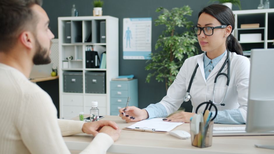 A doctor and patient engaged in consultation in a modern clinic office.