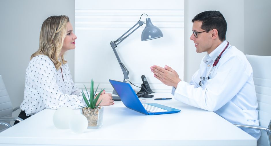 A doctor conducts a patient consultation in a bright, modern medical office.