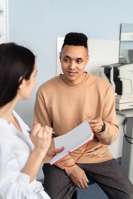 A doctor consulting with a patient in a clinical setting, discussing health concerns.