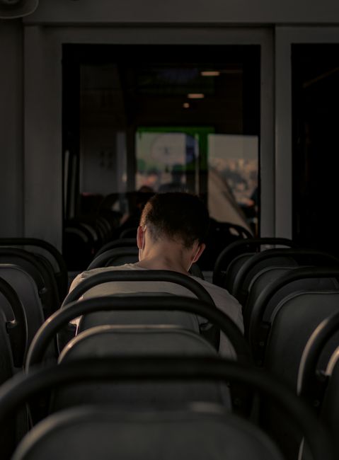 A man sits alone in a dimly lit waiting room, offering a sense of solitude and tranquility.