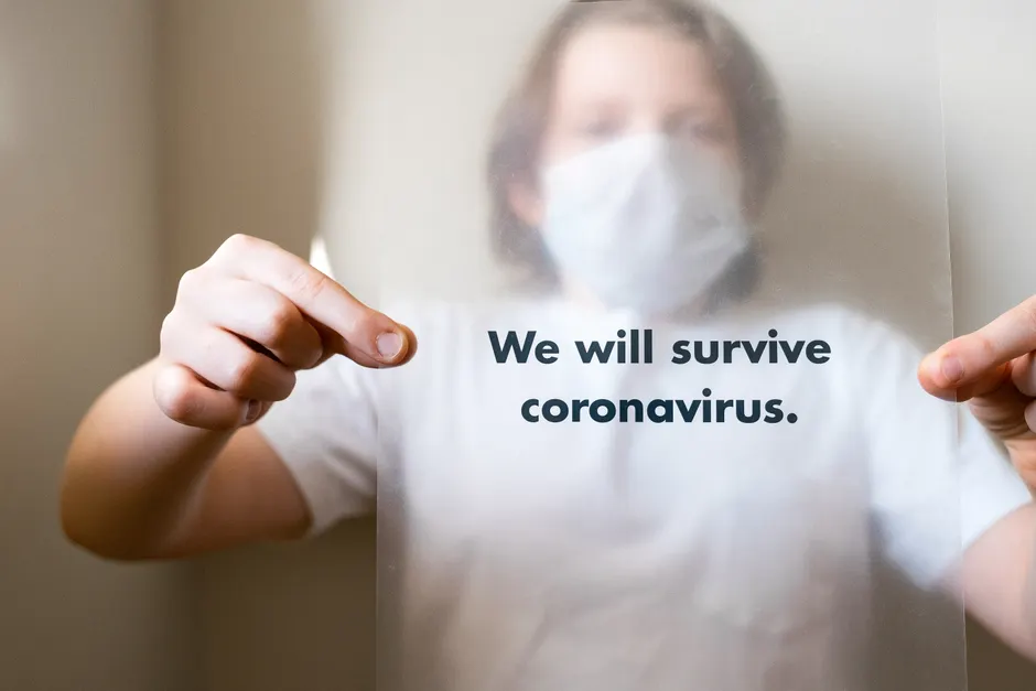 Hospitalisation et trouble bipolaire : ce que montrent les études et comment s’y préparer A person with a mask holding a sheet with 'We will survive coronavirus' message.