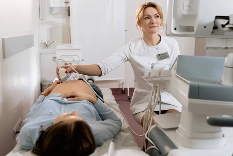 Dépression prénatale : signes, soins et prévention pendant la grossesse A pregnant woman receiving an ultrasound exam conducted by a healthcare professional in a medical clinic.