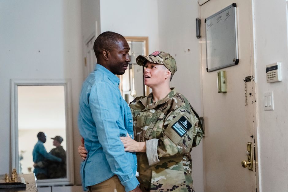 A touching goodbye between a soldier in uniform and their partner, showcasing love and support.