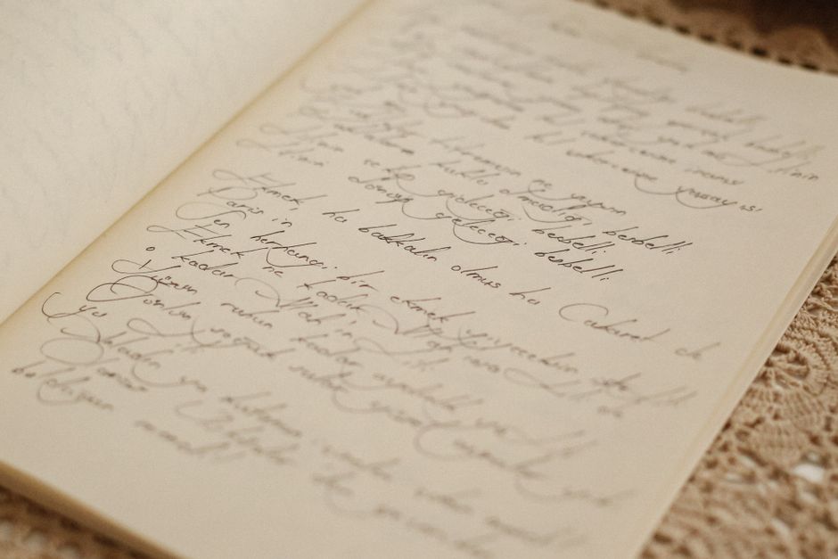 A vintage open journal with elegant handwritten script on a lace tablecloth.