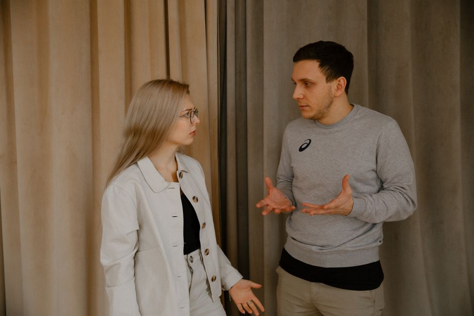 Pardonner après une blessure : responsabilité, excuses et limites A young couple passionately discussing indoors, capturing intense emotions and gestures.