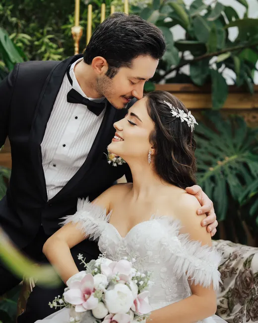 Beautiful wedding couple in Antalya with greenery backdrop, showcasing elegance and romance.