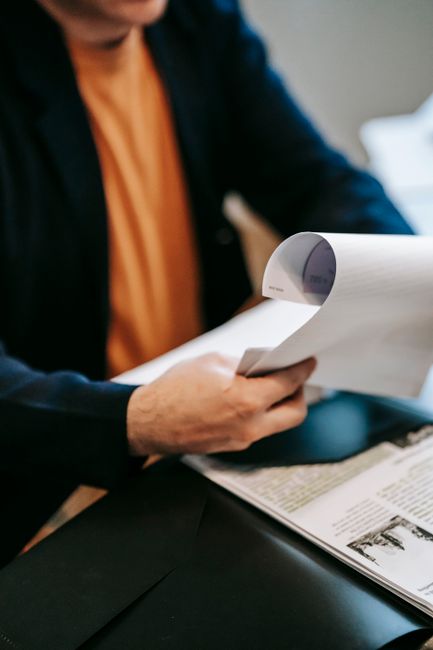 Business professional reviewing important documents indoors. Hands focus, blurred background.